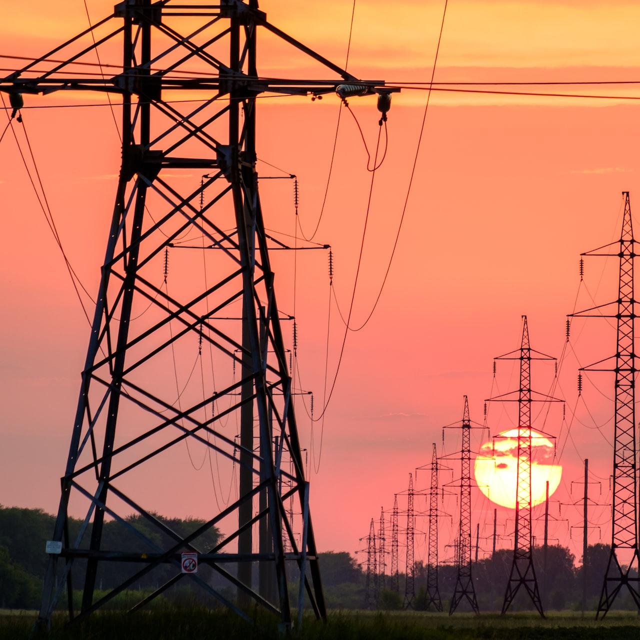 silhouette of electric post during sunset